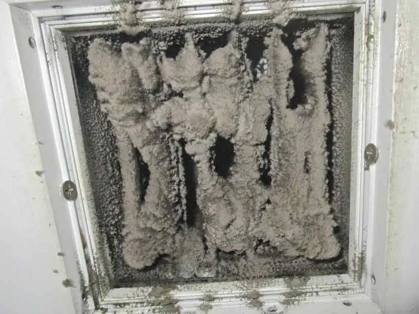 A return grille packed solid with thick grey felted dust
