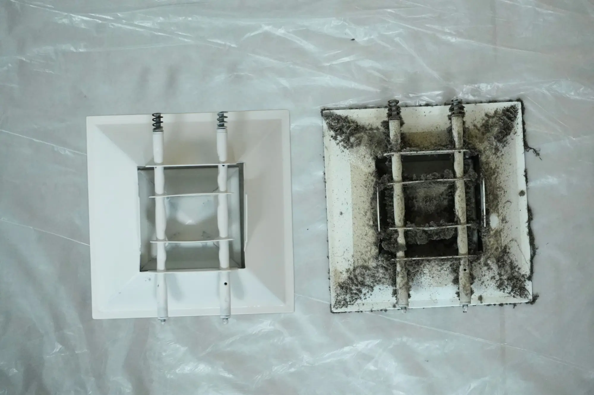 Two identical AC vents side by side, one cleaned and one still coated in dust