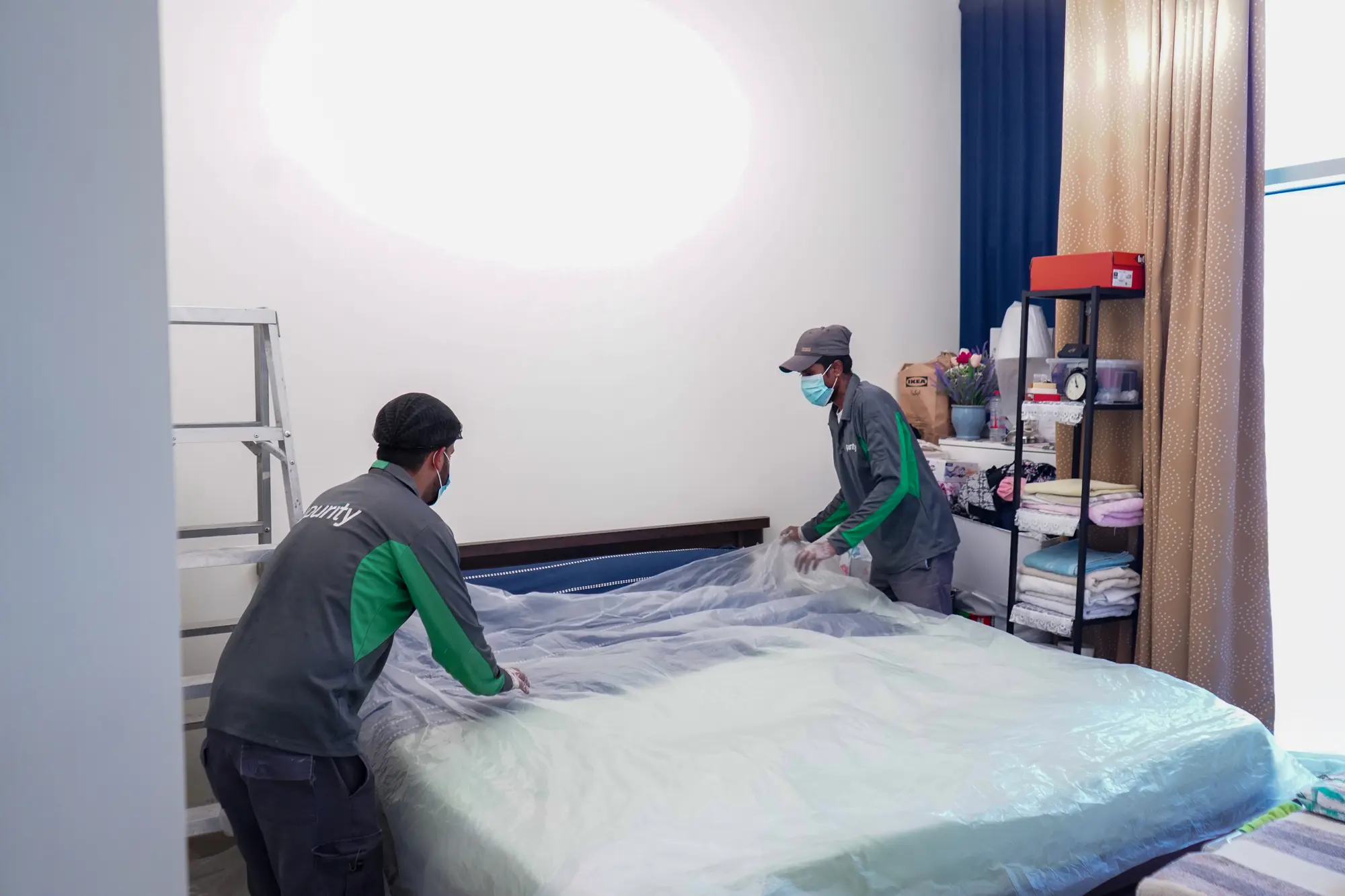 Floor and furniture covered in protective sheeting before work begins