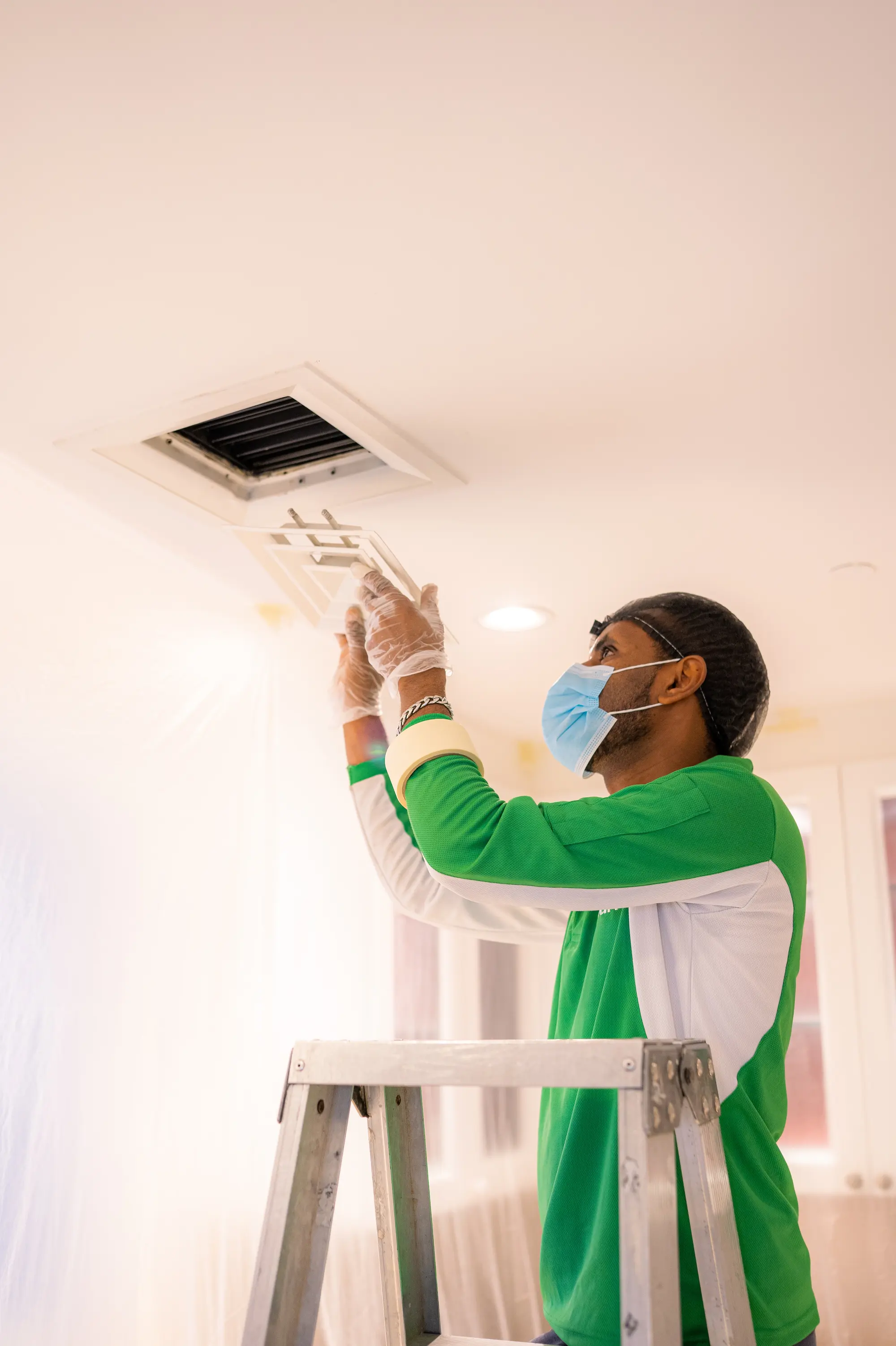 Technician removing a ceiling diffuser